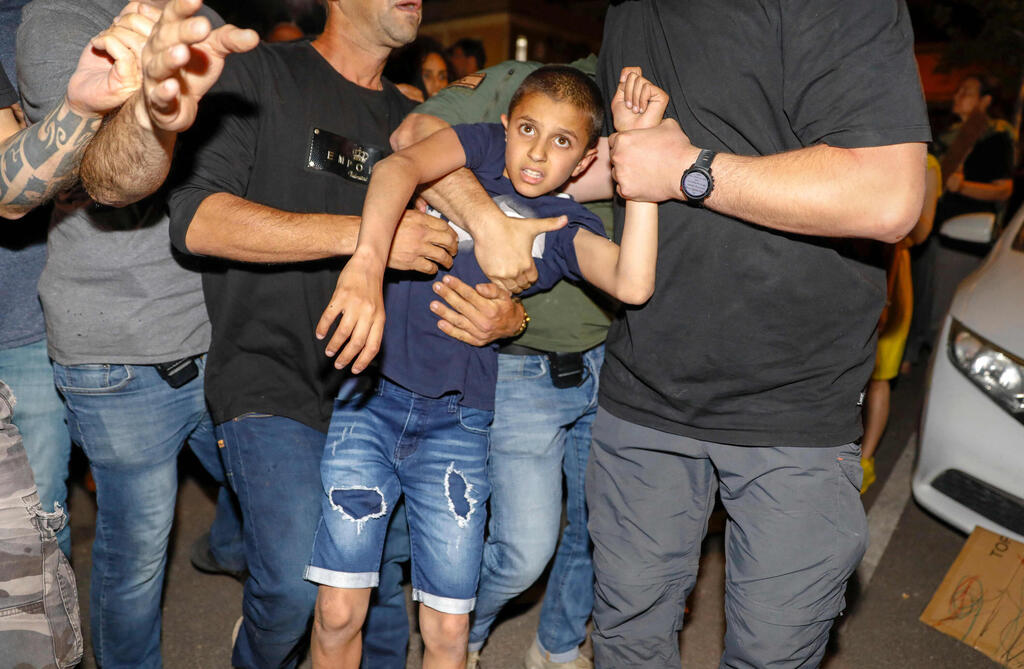 police detain a boy as Israeli left wing protesters and local residents demonstrate against right wing groups attempt to purchase property in the quarter 