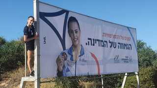 לינוי אשרם עם השלט