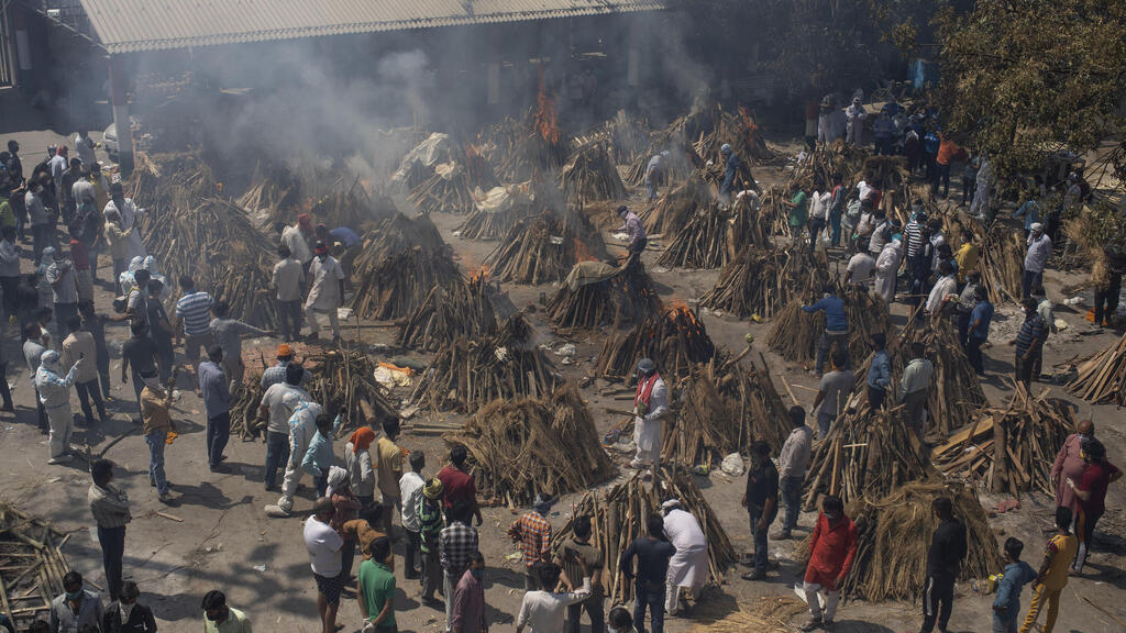 עובדים ב משרפה  של חולי קורונה שמתו ב ניו דלהי הודו