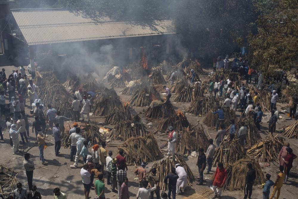 Multiple funeral pyres of those who died of COVID-19 burn at a ground that has been converted into a crematorium for the mass cremation of coronavirus victims, in New Delhi, India 