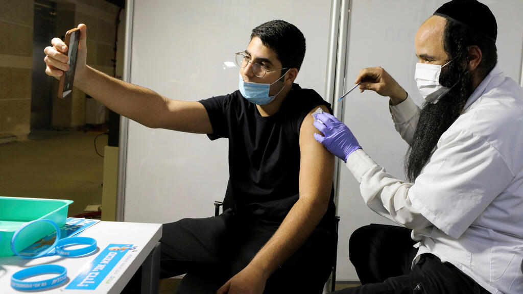 A man receives a vaccination against the coronavirus disease (COVID-19) at a temporary Clalit healthcare maintenance organisation (HMO) vaccination centre, at a sports arena in Jerusalem 
