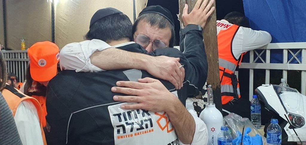 Emotional rescue workers share a hug at the scene of the Meron disaster 