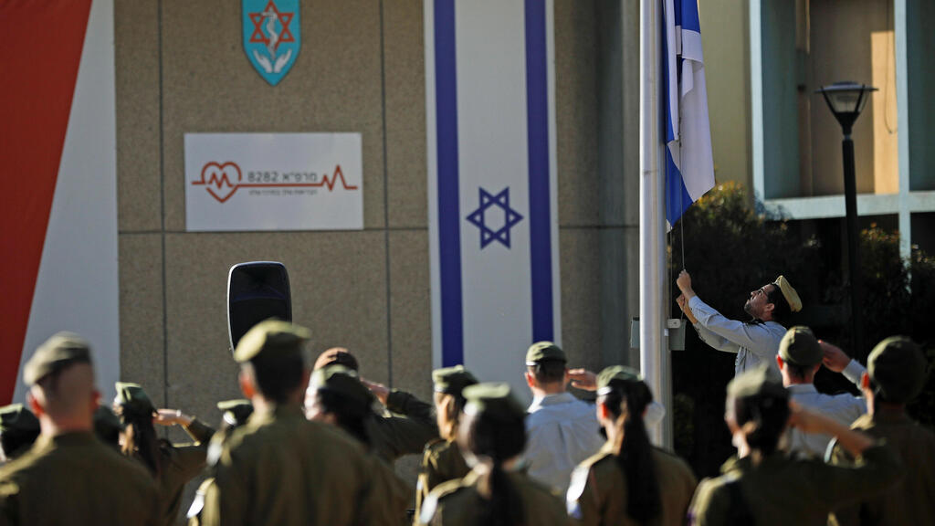 Israeli soldiers stand in formation as the national flag is lowered to half-mast as the country observes a day of mourning 