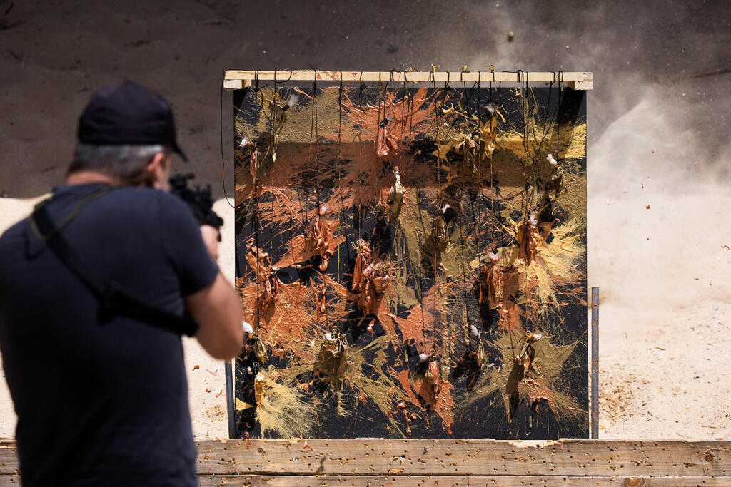 Roytman uses gun to apply paint in art work 