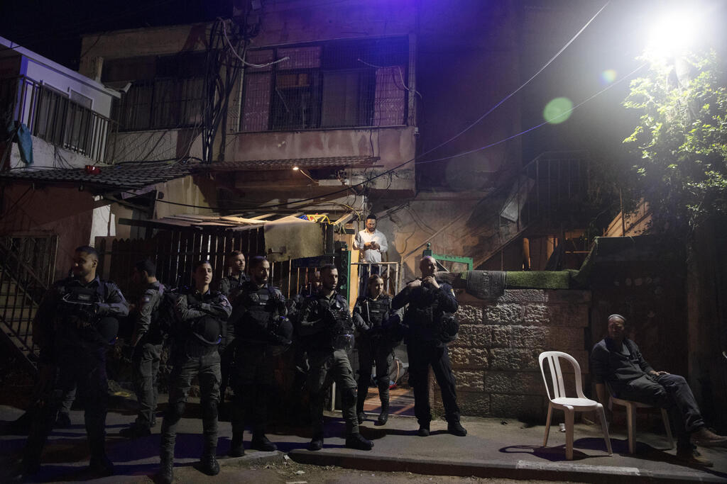 Israeli police stand guard in front of a Palestinian home occupied by settlers during a protest on the eve of a court verdict that may forcibly evict Palestinian families from their homes in the Sheikh Jarrah neighborhood of Jerusalem 