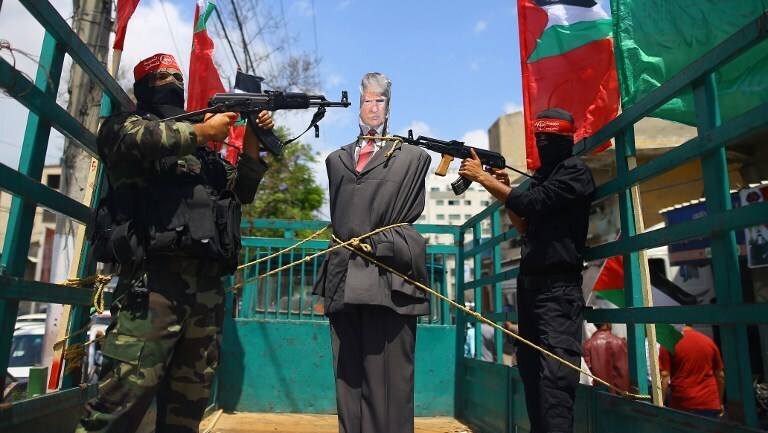 Palestinian terrorists from the Popular Front for the Liberation of Palestine (PFLP) aim their weapons at an effigy depicting US President Donald Trump 