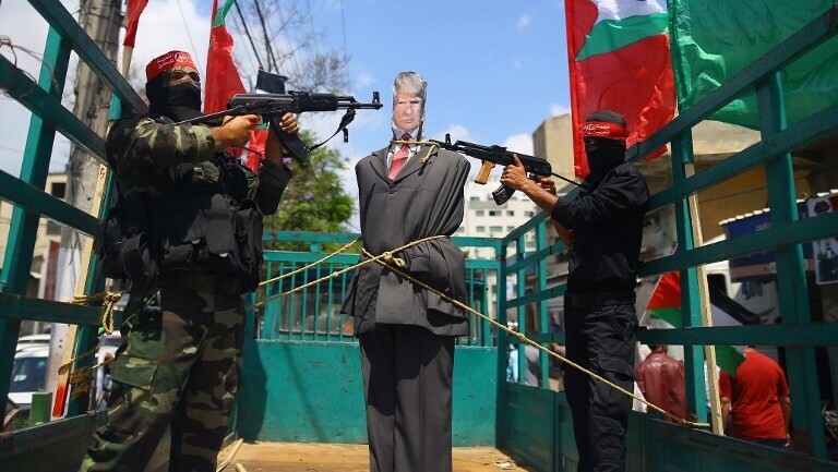 Palestinian terrorists from the Popular Front for the Liberation of Palestine (PFLP) aim their weapons at an effigy depicting US President Donald Trump 