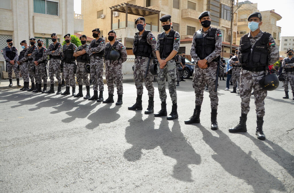 Security forces stand guard as Jordanians demonstrate to express solidarity with the Palestinian people, near the Israeli embassy in Amman, Jordan 