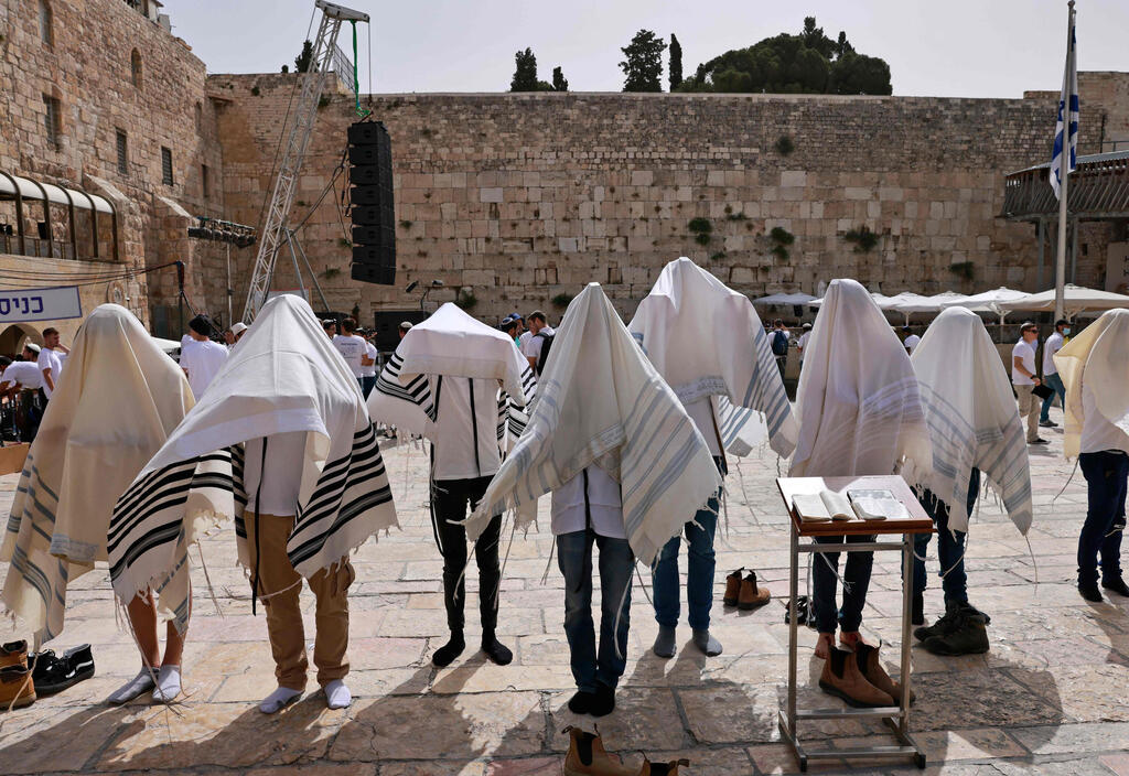 Jewish men pray near the Western Wall in the Old City of Jerusalem as Israel marks Jerusalem Day, May 10, 2021 