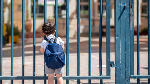 ילד ליד שער בית הספר