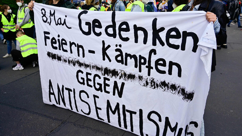 Demonstrators hold a banner reading "May 8th, commemoration, celebrate, fight against antisemitism" during a protest in Berlin  