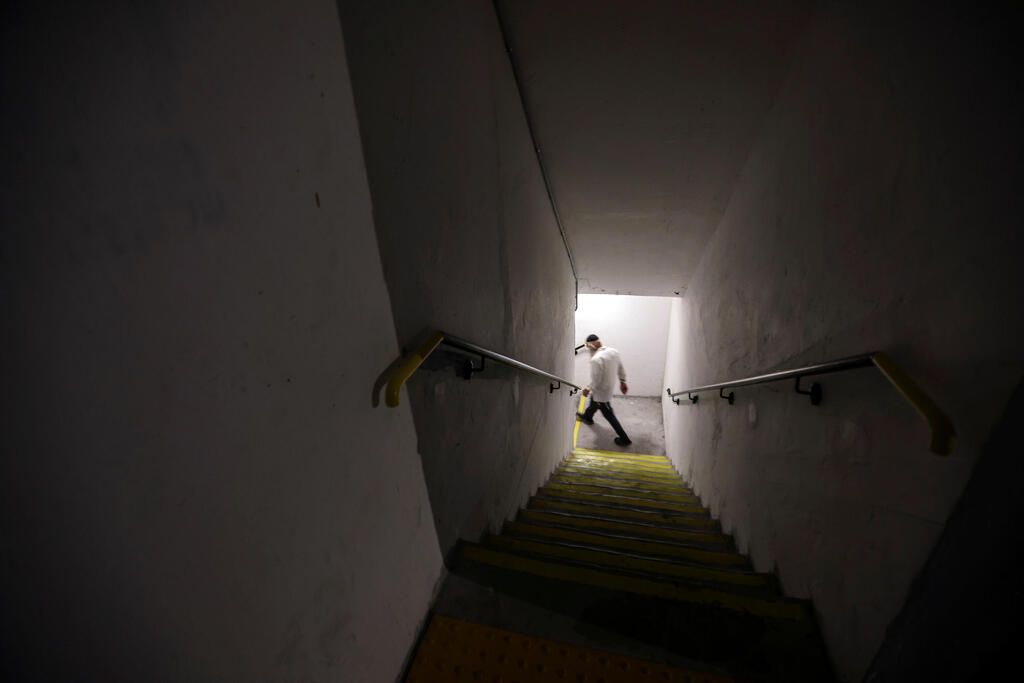An Israeli man walks down the stairs into a bomb shelter as Israeli-Palestinian cross-border violence continues, in Ashkelon, southern Israel 