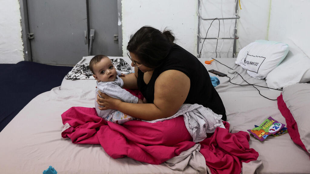 Tsvia Ganon, 28, five-month-old boy, Ori, sit inside a bomb shelter as Israeli-Palestinian cross-border violence continues, in Ashkelon, southern Israel 