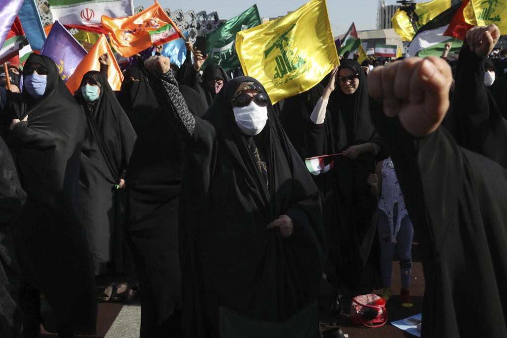 Demonstrators wave Hezbollah flags on a gathering in Tehran, Iran