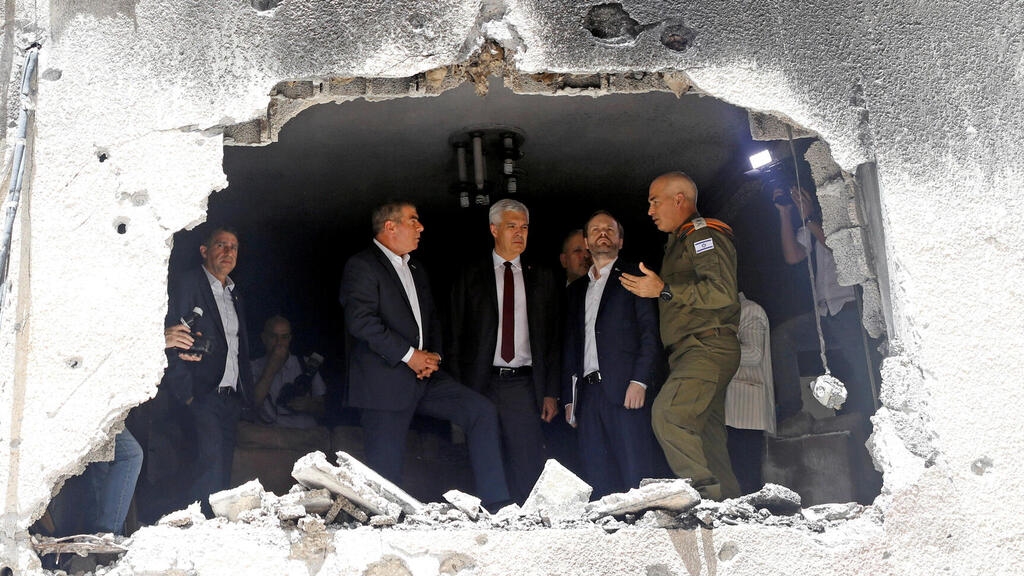 Foreign Minister Gabi Ashkenazi speaks to his Czech counterpart Jakub Kulhanek and Slovak counterpart Ivan Korcok as they visit the site of a building damaged by a rocket launched from the Gaza Strip last week, in Petah Tikva, Israel May 20,