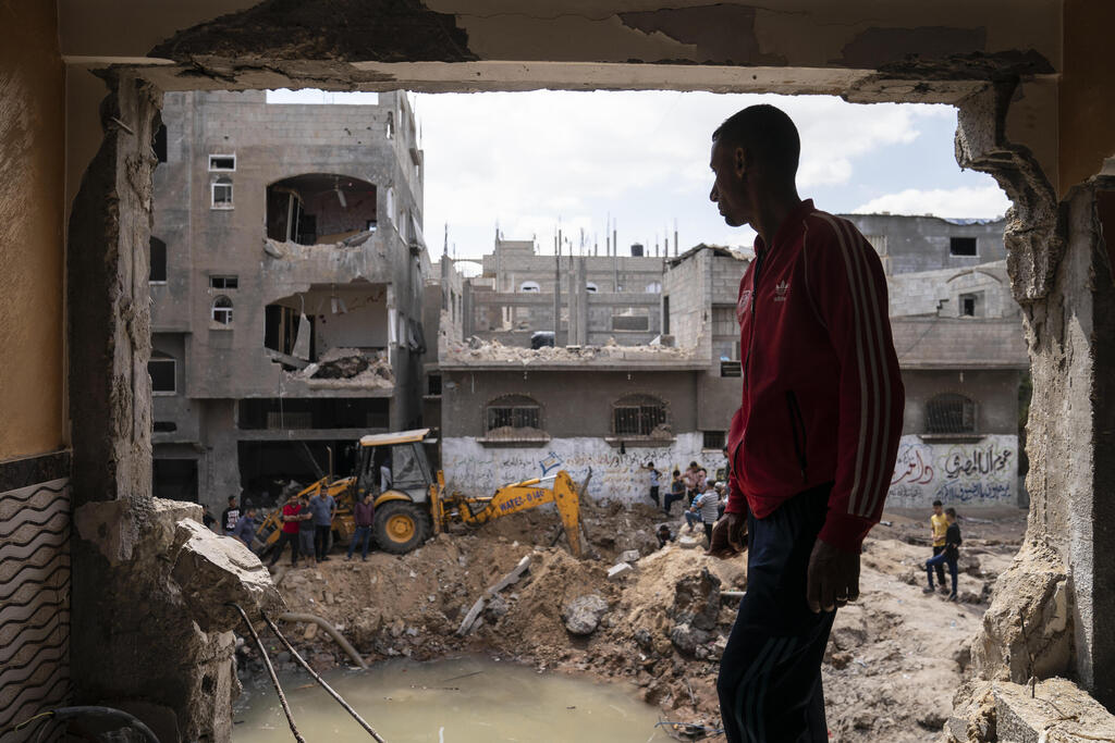 Nader al-Masri stands inside his severely damaged home 