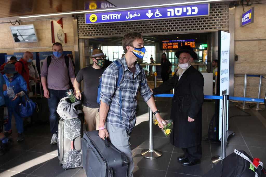 Tourists walk at the Ben Gurion International Airport after entering Israel 