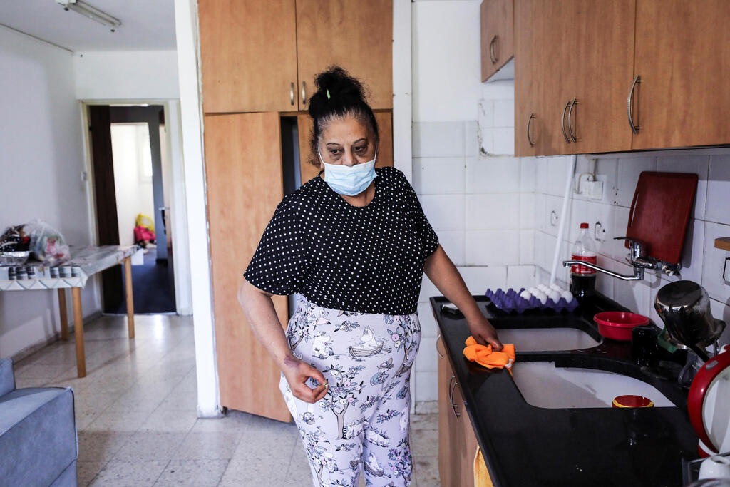 Randa Aweis, who received a kidney donation from Yigal Yehoshua, who died after succumbing to his wounds sustained in an attack by Arab lynchers in the mixed city of Lod, looks on while standing in her kitchen at her home in Jerusalem May 26, 2021