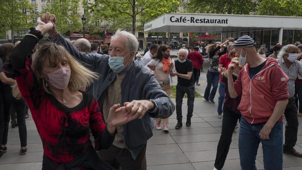 a couple with protective masks on dance at Republic square in Paris