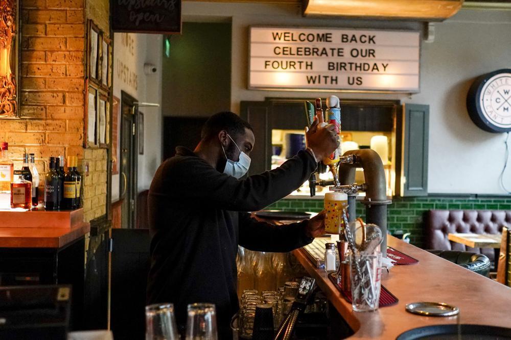  a bartender pours a pint of beer at the Prince of Peckham pub, as it reopens to indoor customers, in London