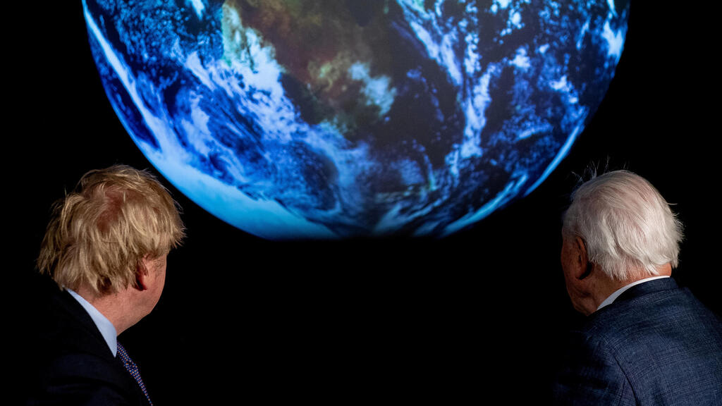 British Prime Minister Boris Johnson and David Attenborough look at a projection of planet Earth 