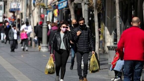 People carry shopping bags as Israel reopens swathes of its economy, while it continues to lift restrictions of a national lockdown to fight the coronavirus disease (COVID-19), in Jerusalem 