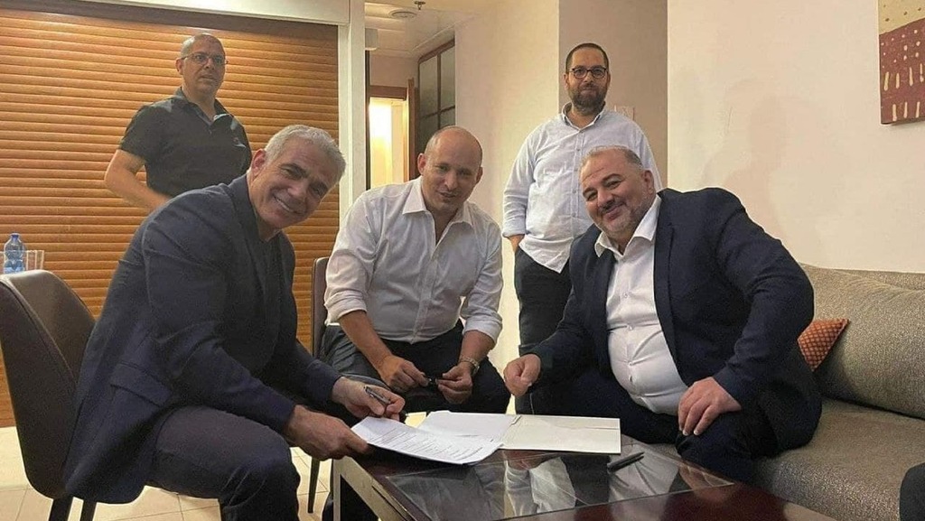 Мансур Аббас подписывает соглашение (Фото: Науф Аль-Навари) עבאס, בנט ולפיד לאחר החתימה בפגישה בכפר המכבייה