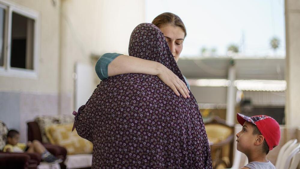 Jewish resident Katya Michaelov, right, embraces her Arab neighbor, Obaida Hassuna, as she comes to pay her respects with her son, Adam, 7, after Hassuna's son, Musa, was killed in recent clashes between Arabs and Jews in the mixed Arab-Jewish town of Lod, 