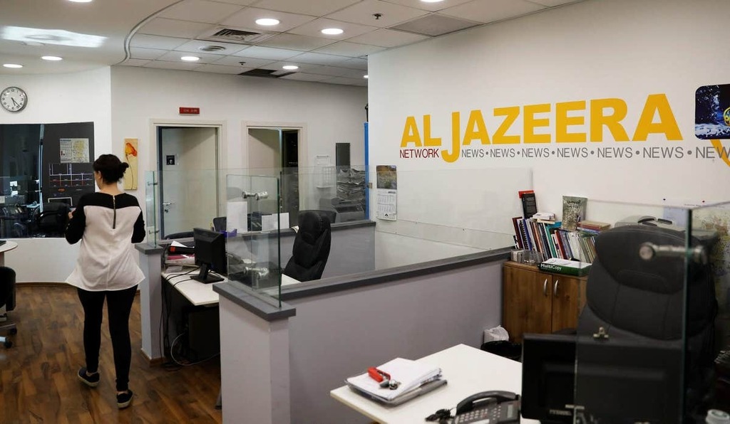 An employee walks inside an office of Qatar-based Al-Jazeera network in Jerusalem 