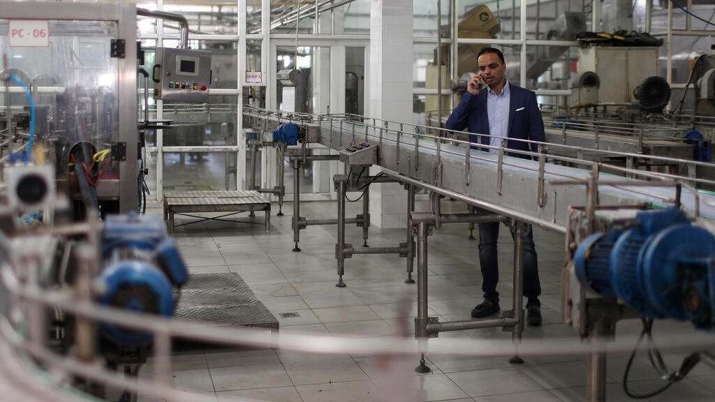 Palestinian Hamam Al-Yazeji, a director of Gaza Pepsi factory for soft drinks, speaks on the phone at the factory, in Gaza 