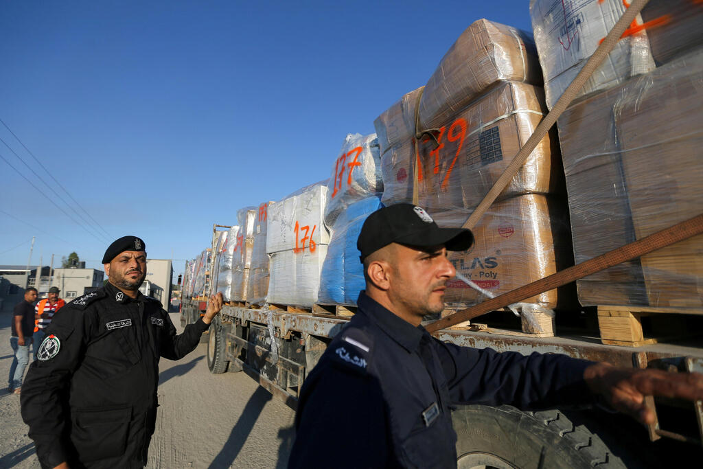 Palestinian police officers stand next to a truck carrying clothes for export at Kerem Shalom crossing in Rafah in the southern Gaza Strip,