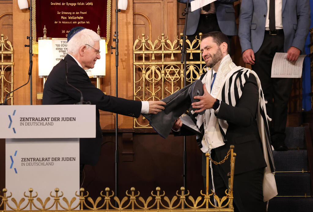 Josef Schuster (L), President of the Central Council of Jews in Germany, hands Rabbi Zsolt Balla a protective torah cover following the ceremony in which Balla was officially inaugurated as the first federal rabbi of the Bundeswehr, Germany's armed forces, at the main synagogue in Leipzig 