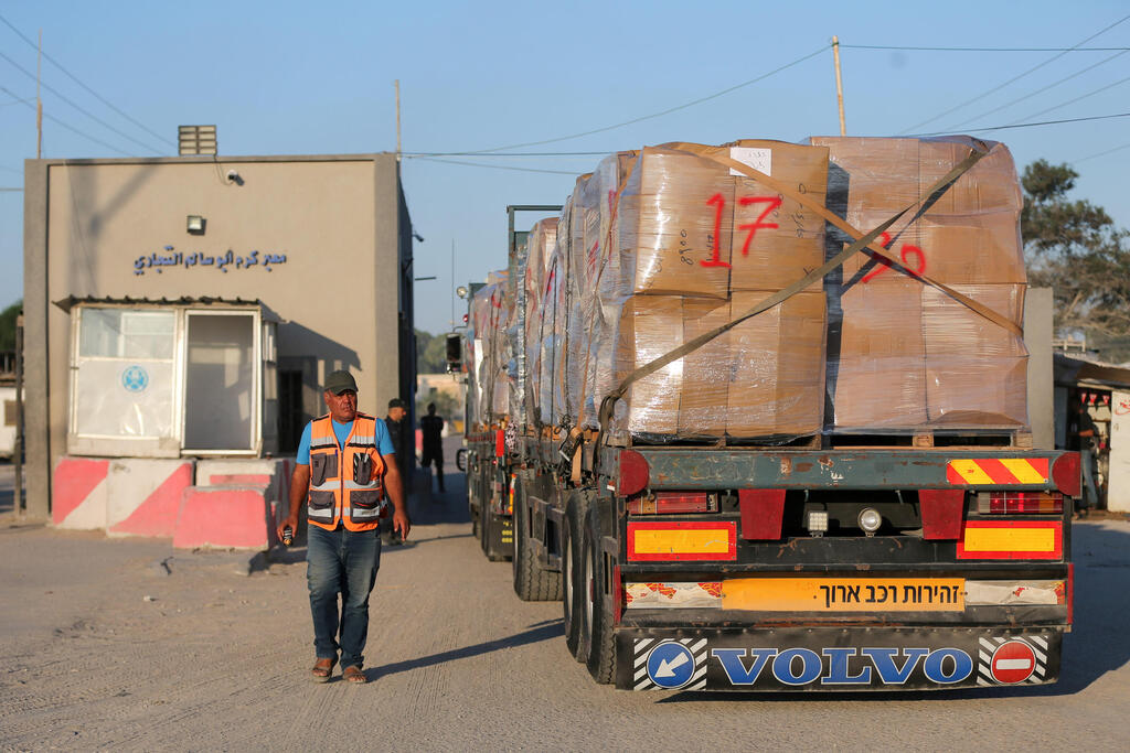  Palestinian man stands next to a truck carrying clothes for export, at Kerem Shalom crossing in Rafah in the southern Gaza Strip,