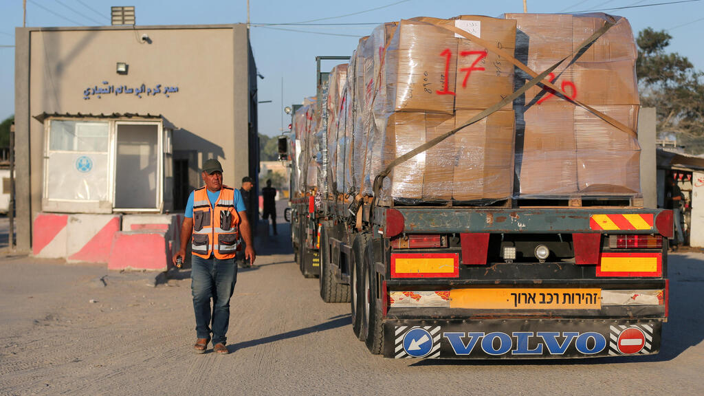  Palestinian man stands next to a truck carrying clothes for export, at Kerem Shalom crossing in Rafah in the southern Gaza Strip,