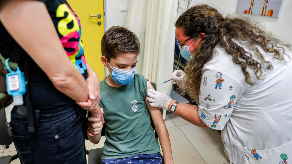 A child receiving his coronavirus vaccine in Holon (Photo: AFP) מחסנים בני נוער בחולון