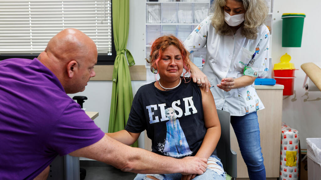 A teenager reacts while receiving a dose of the coronavirus vaccine at a Tel Aviv clinic, June 21, 2021 