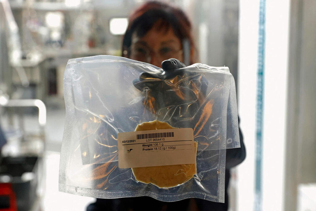 A technician displays a lab-grown chicken meat in a sealed bag at the food-tech startup SuperMeat in the central Israeli town of Ness Ziona 