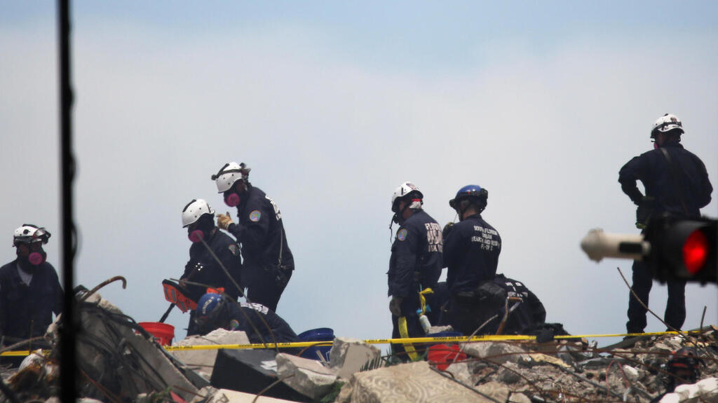 Rescue teams search for survivors at the site of the collapse in Surfside outside Miami on Monday 