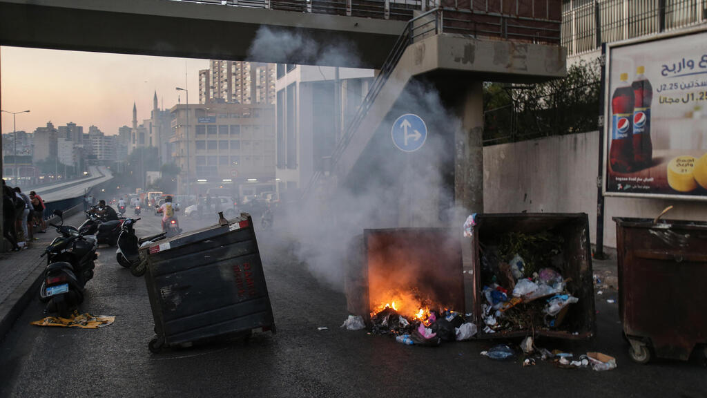  Anti-government protesters burn waste bins to block a highway that leads to the airport during a protest in Beirut, Lebanon, 26 June 2021