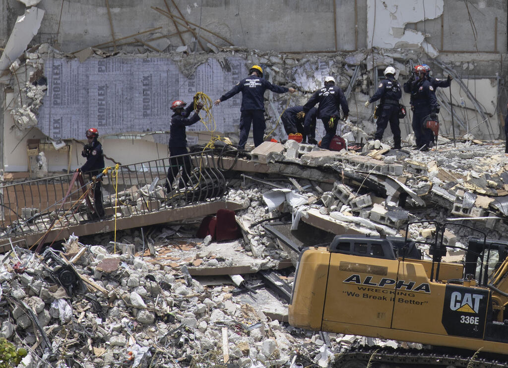 Rescue workers search in the rubble at the Champlain Towers South condominium in the Surfside area of Miami 
