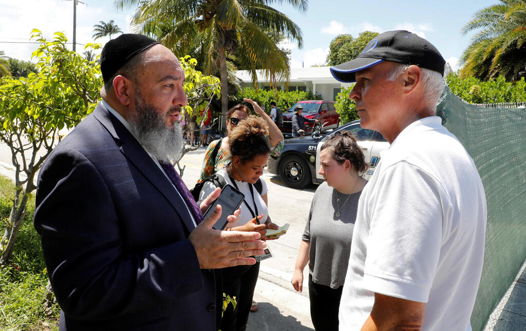 Rabbi Yosef Galimidi (L) speaks with Surfside Mayor Charles Burkett near the site of a partially collapsed residential building in Surfside, near Miami Beach, Florida, U.S. June 27, 2021