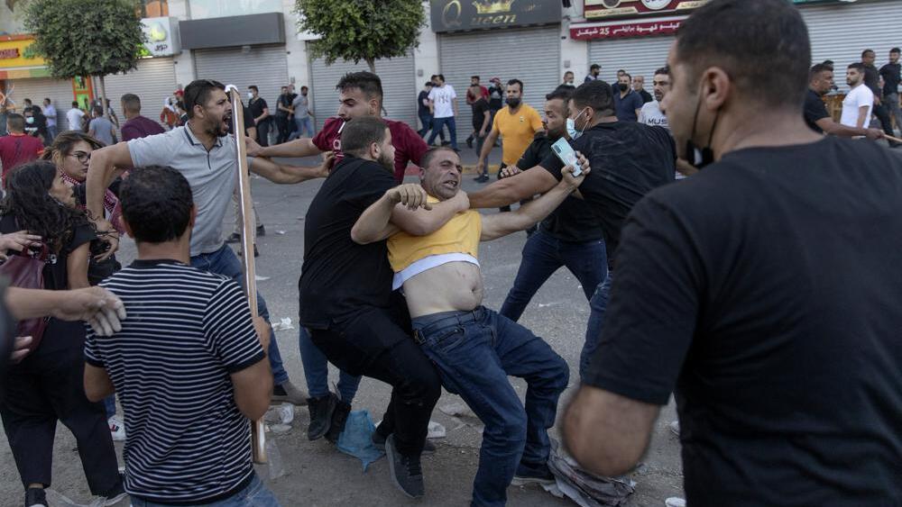 Palestinian security officers in plainclothes detain a demonstrator during clashes that erupted following a rally protesting the death of Palestinian Authority outspoken critic Nizar Banat, in the West Bank city of Ramallah, Saturday, June 26, 2021