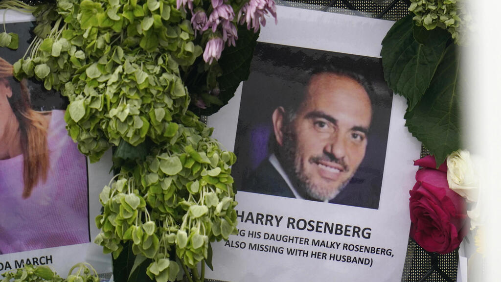 Image of Harry Rosenberg, missing since an oceanfront condo building collapsed in Surfside, Fla., hangs on a fence as part of a makeshift memorial  