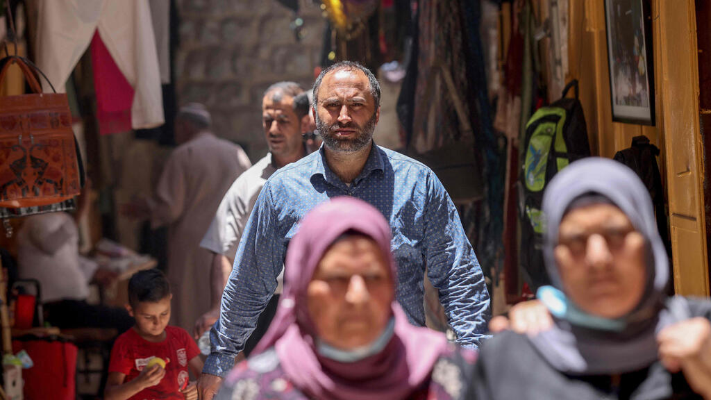 Human rights activist Issa Amro walks through the market in Hebron