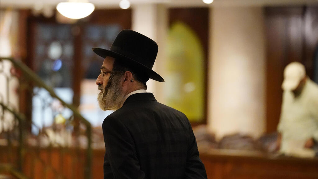An Orthodox Jewish man walks inside the Shul of Bal Harbour  
