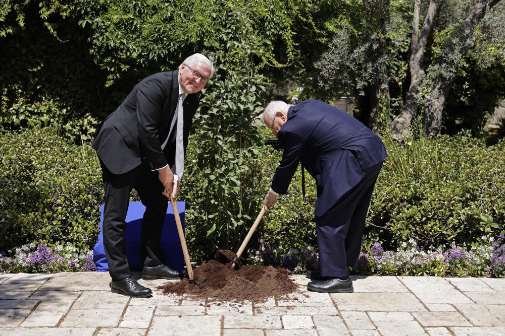 President Reuven Rivlin, right, and German President Frank-Walter Steinmeier plant a tree, at the President's residence in Jerusalem 