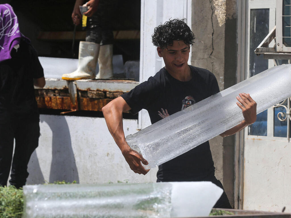 קונים בלוקים של קרח במפעל ממזרח ל בגדד עיראק גל חום