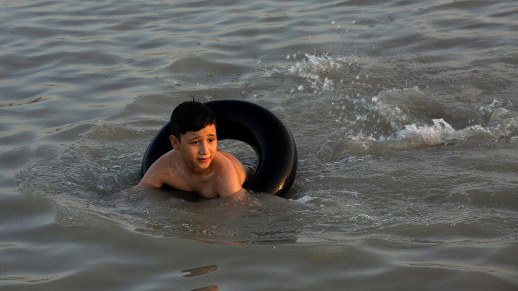 מתרחצים בנהר שט אל ערב בצרה דרום עיראק גל חום