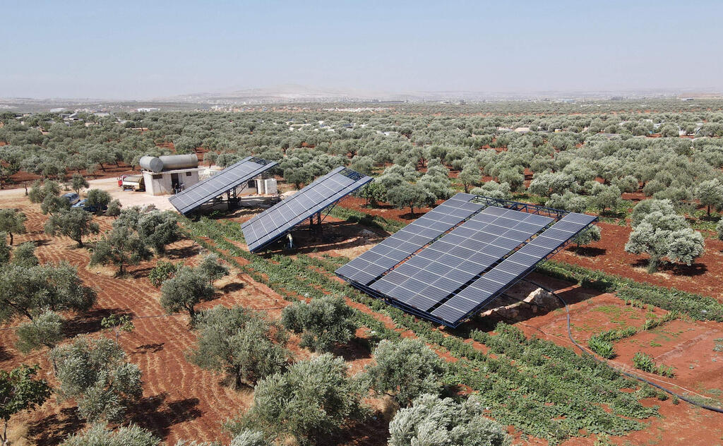This aerial picture shows solar panels installed in agricultural fields, in the village of Killi, near Bab al-Hawa by the border with Turkey, in Syria's northwestern Idlib province, on June 9, 2021