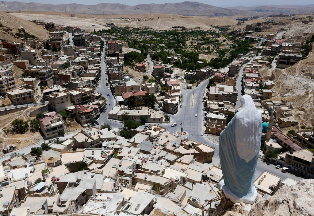 A statue of the Virgin Mary overlooks the village of Maalula 